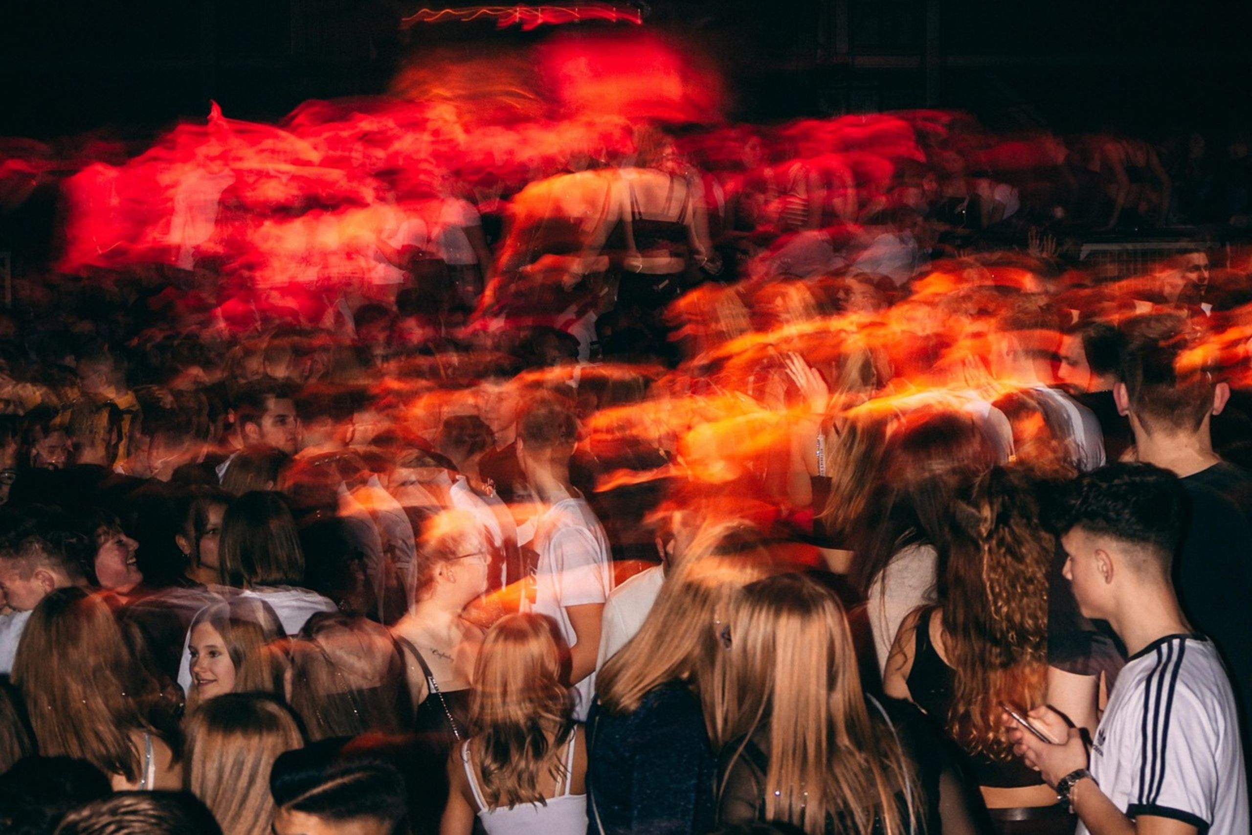 Foule entrant dans l'enceinte d'un festival à la tombée de la nuit